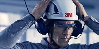 Uomo che parla nelle cuffie delle soluzioni di comunicazione protettive 3M
