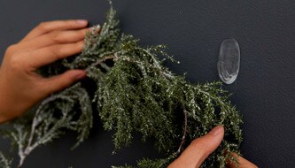 Persona che appende la decorazione di Natale a parete
