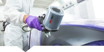 Verniciatore che spruzza vernice su un'auto utilizzando una pistola spray 3M

