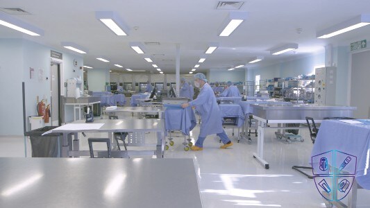 L'operatore spinge un carrello di strumenti attraversando la centrale di sterilizzazione
