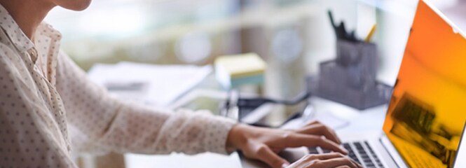 Donna che lavora su un laptop con filtro privacy 3M™ oro
