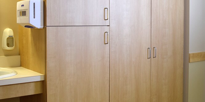 Lavandino e armadietti di stanza d'ospedale con rivestimento 3M DI-NOC in legno chiaro
