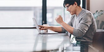 Uomo seduto a un tavolo mentre lavora su un laptop
