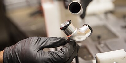 Scopri di più sull'incollaggio dei materiali. Immagine di tubi metallici che vengono incollati con adesivo liquido.
