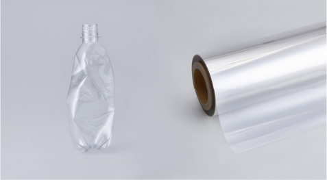 bottiglia di plastica accanto a un rotolo di pellicola architettonica DI-NOC
