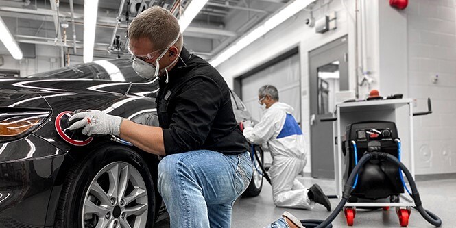 Immagine che mostra un uomo che utilizza abrasivi e strumenti di alta qualità su un'auto per ottenere risultati eccellenti.
