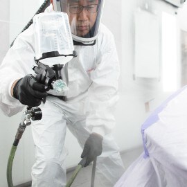 Un verniciatore che spruzza primer per auto utilizzando un aerografo ad alte prestazioni 3M