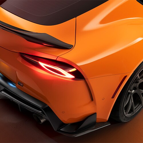 Particolare lato passeggero posteriore di auto sportiva con pellicola per wrapping arancio