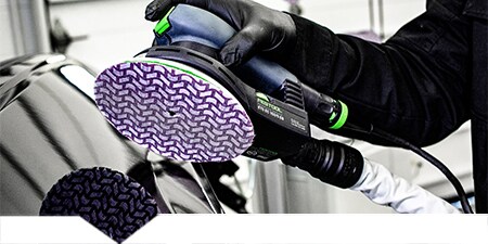 Tecnico che carteggia un pannello dell'auto danneggiato
