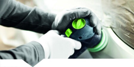 Tecnico che lucida il pannello di un auto

