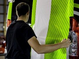 Persona che applica una pellicola da wrapping verde al veicolo