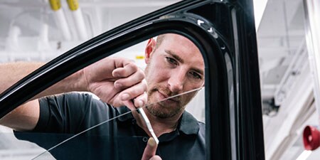 Uomo che installa la pellicola per i vetri dell'auto

