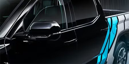 Dettagli di pellicola wrapping blu brillante e bianco su furgone nero.
