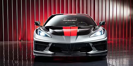 Wrapping parziale rosso e nero sul cofano di coupé grigia.
