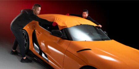 pellicola adesiva per auto arancione installata da due installatori

