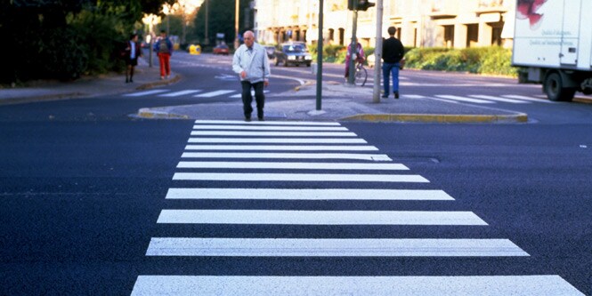 Persone che attraversano strade con attraversamenti pedonali
