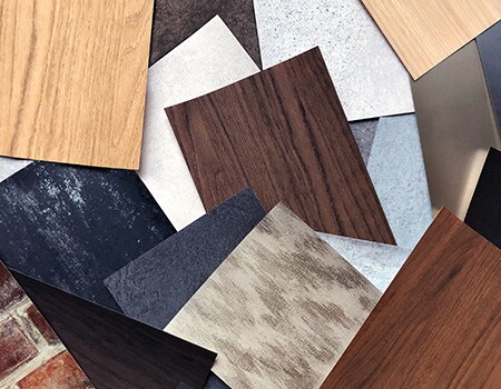Campioni di finiture di superfici con venature del legno, toni metallici e motivi diversi.
