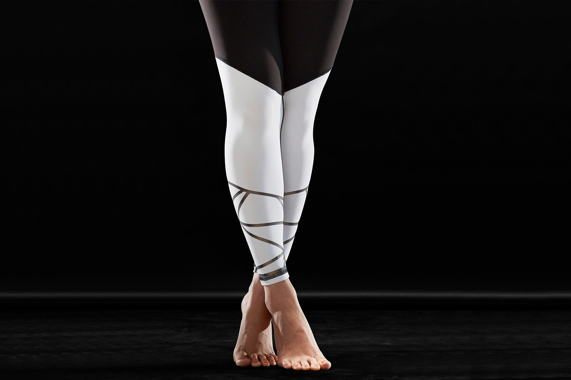 Donna che indossa calze bianche con materiale riflettente elastico nero Scotchlite che risalta sulle punte dei piedi