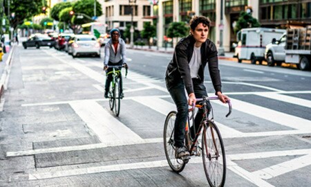 Persone in bicicletta lungo una strada in città
