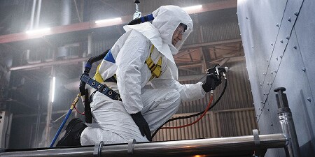 Lavoratore che vernicia con DPI 
