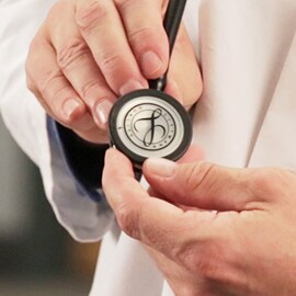 Primo piano di un medico che tiene la testina di uno stetoscopio 3M Littmann con il sigillo Littmann sulla membrana.
