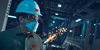 Lavoratore che indossa un respiratore monouso 3M e un copricapo
