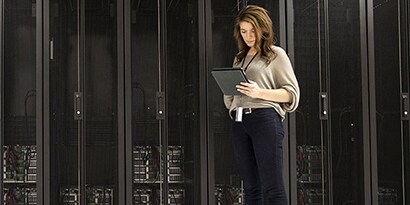 Donne d'affari di diverse razze che usano un tablet in una sala server
