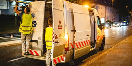 Furgone sul lato di una strada con segnaletica riflettente a V

