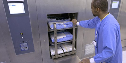 L'operatore spinge il carrello degli strumenti nella sterilizzatrice
