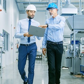 Ingegneri che attraversano un impianto di produzione automatizzato