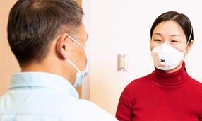 Medico che indossa un DPI con un paziente
