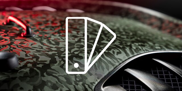 Particolare di pellicola per wrapping auto con motivo mimetico su cofano con icona swatch
