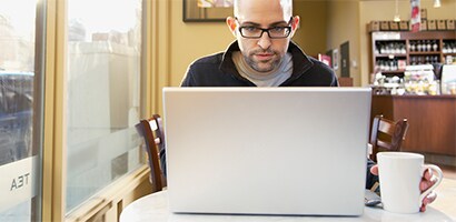 Persona al lavoro su un computer portatile in pubblico
