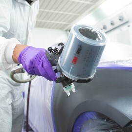 Uomo che spruzza vernice per auto utilizzando l'aerografo ad alte prestazioni 3M PPS Serie 2.0