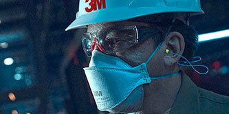 Un lavoratore che indossa un respiratore monouso
