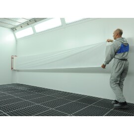 Uomo che applica 3M Dirt Trap su una parete di una cabina di verniciatura 