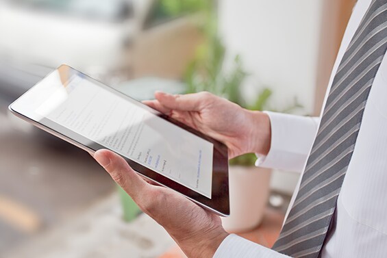 Uomo che guarda un iPad su cui è applicato un prodotto per la protezione dello schermo 3M.
