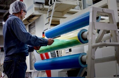 lavoratore che rimuove una lastra flessografica da una lastra flessografica su un cilindro
