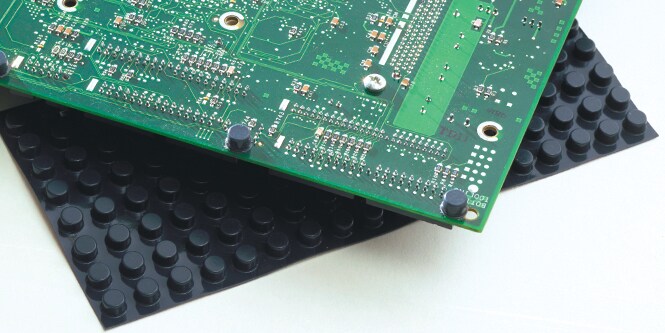 Primo piano di una scheda elettronica sopra un tappetino di cuscinetti in gomma Bumpon.
