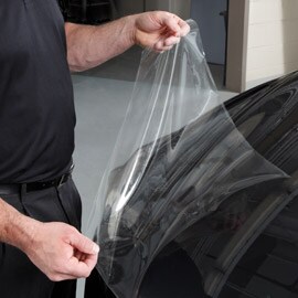 Persona che applica pellicola paint protection film all'auto