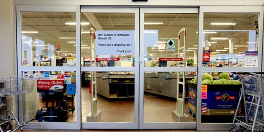 Un'immagine contenente l'ingresso del negozio con un adesivo
