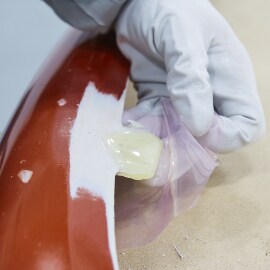 Modellare l'adesivo manualmente per forzarlo all'interno dei fori