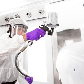 Verniciatore che spruzza primer su una parte